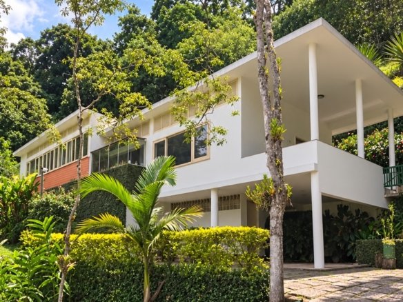 Fachada da Casa Recanto em Itaipava, cercada por jardim e vegetação